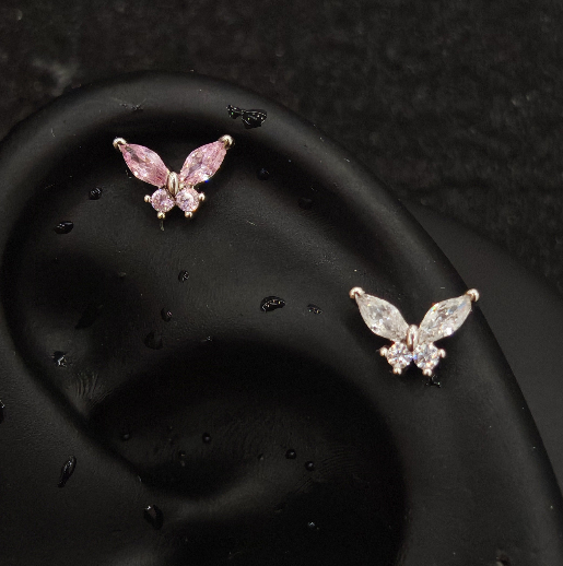 Titanium butterfly marquise CZ piercing studs in pink and white worn on ear cartilage helix, silver tone flat-back labret with marquise wing and round body CZ stones